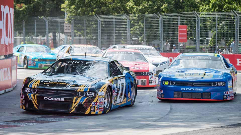 Stock cars speeding through the Honda Indy Toronto track