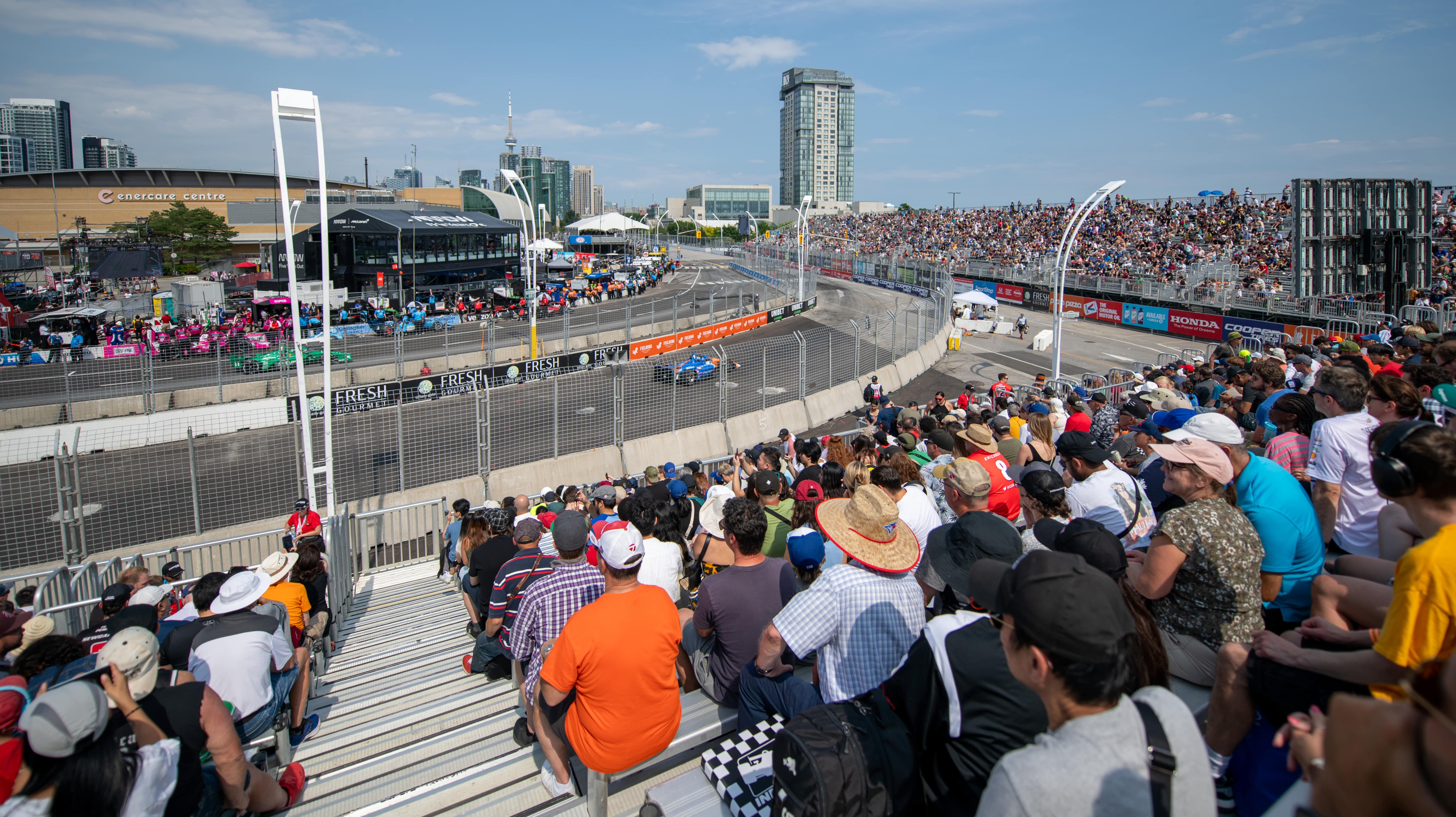 A crowded grandstand at the Honda Indy Toronto atop sponsor signage