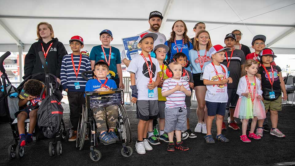 James Hinchcliffe poses takes a photo with kids from the Make-A-Wish Foundation