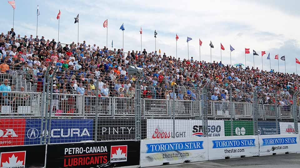 A crowded grandstand at the Honda Indy Toronto atop sponsor signage